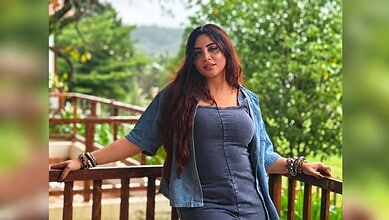 Arshi Khan posing outdoors with greenery in the background, wearing a denim jacket and top.
