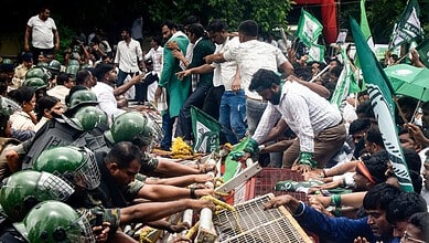 Bhubaneswar: Security personnel stop Biju Janata Dal (BJD) youth and student wing members during a protest over alleged errors in school textbooks, demanding the resignation of state School and Mass Education Minister Nityananda Gond, in Bhubaneswar, Odisha, Wednesday, Sept. 23, 2026. (PTI Photo)
