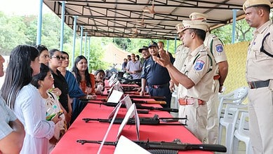 Cyberabad police officers demonstrate firearms to influencers at a public event.