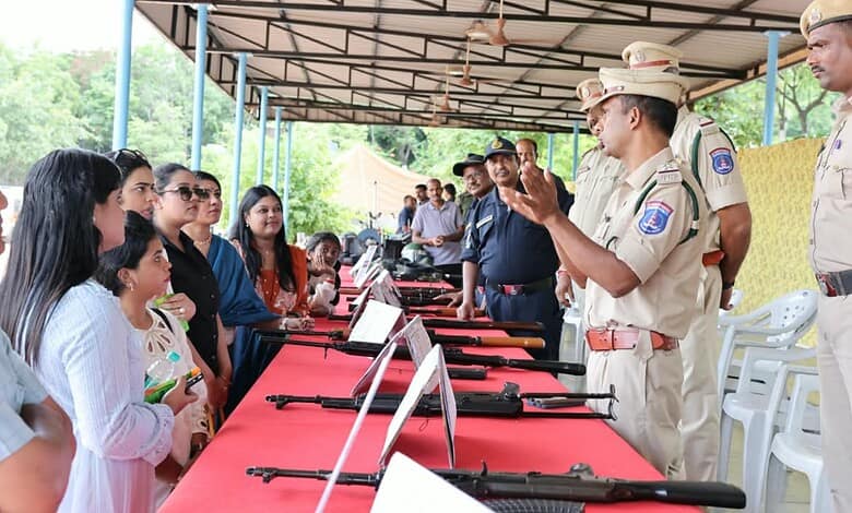 Cyberabad police officers demonstrate firearms to influencers at a public event.