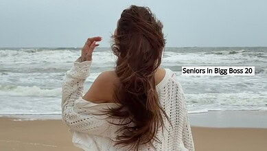 Woman with long hair on the beach, facing the sea, in a white sweater, seniors in Bigg Boss 20.