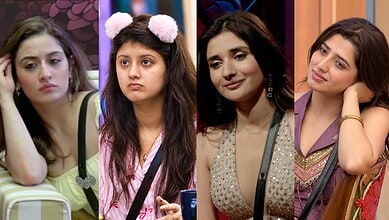 Four women with different expressions, sitting indoors, in a casual setting.