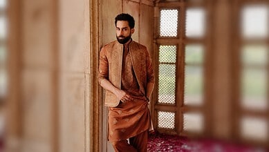 Bilal Abbas Khan wearing traditional attire, standing indoors with a wooden window in the background.
