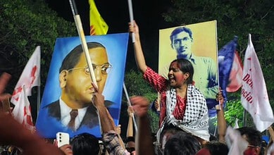 Young girl protesting with flags and portraits during HCU elections rally.
