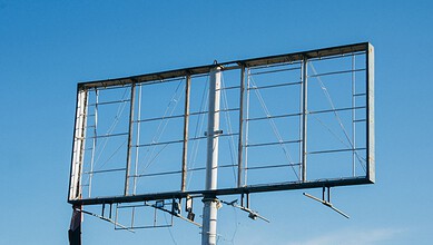 Empty billboard frame against a clear blue sky in Hyderabad.