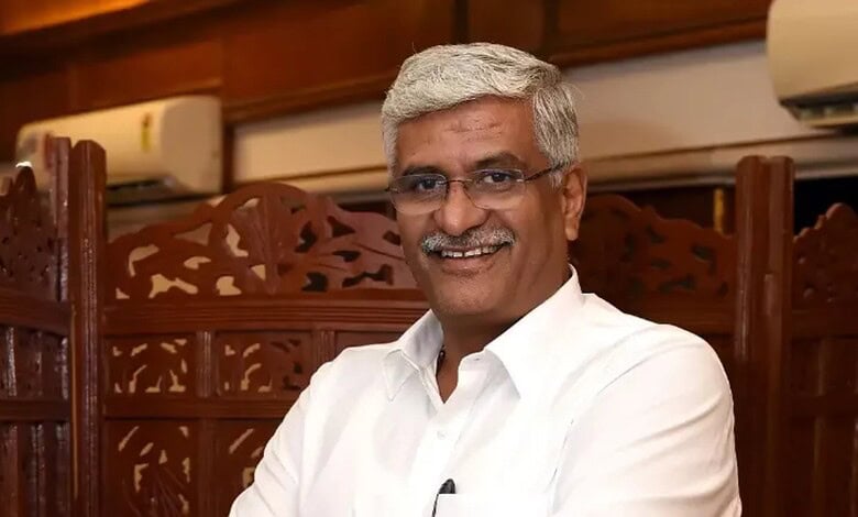 Shekhawat smiling in a formal setting, wearing a white shirt and glasses.