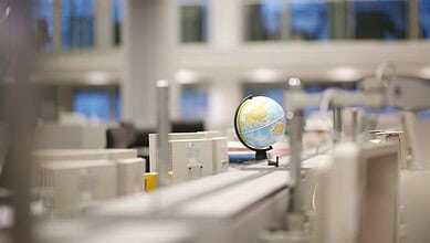 Modern laboratory with computers and a globe, focusing on science and technology.