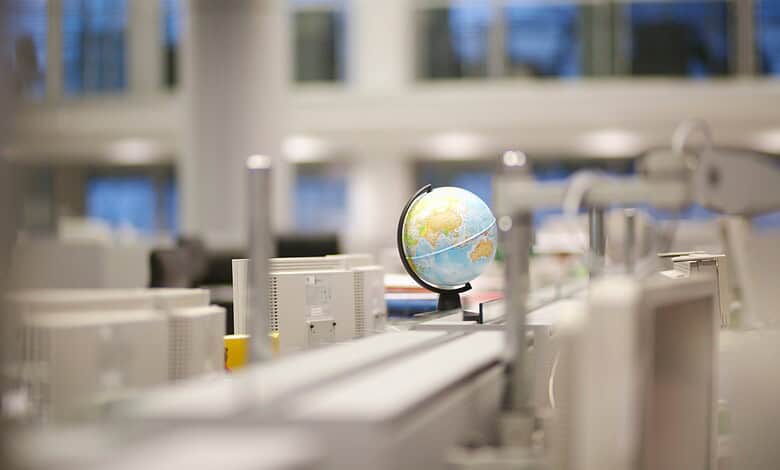 Modern laboratory with computers and a globe, focusing on science and technology.