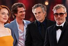 Hollywood stars at an event, dressed elegantly, smiling and posing for the camera.