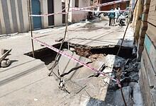 Road collapse on Hussaini Kothi Road due to stormwater drain failure, causing a large sinkhole.