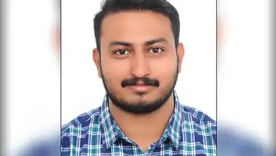 Indian man with a beard and checked shirt, smiling, celebrating his Rs 6L Big Ticket win.