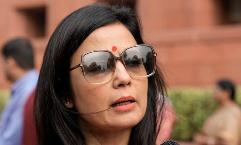 Mahua Moitra speaking at the UN, wearing glasses and a red bindi, with a serious expression.