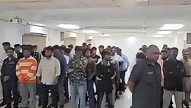 Crowd of police officers and civilians gathered in an indoor space during a public event.