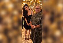 Mouni Roy seeking blessings from Rahat Fateh Ali Khan at an event with festive lighting.