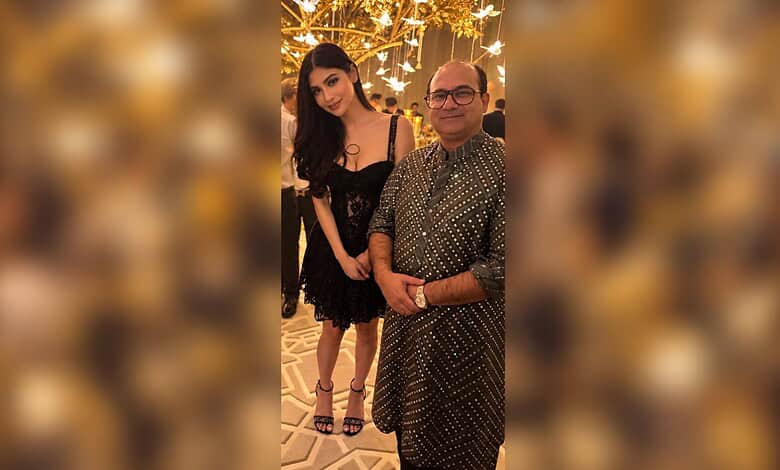 Mouni Roy seeking blessings from Rahat Fateh Ali Khan at an event with festive lighting.