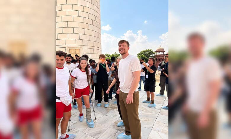 Group of tourists at Taj Mahal with a smiling man in white shirt in the centre.