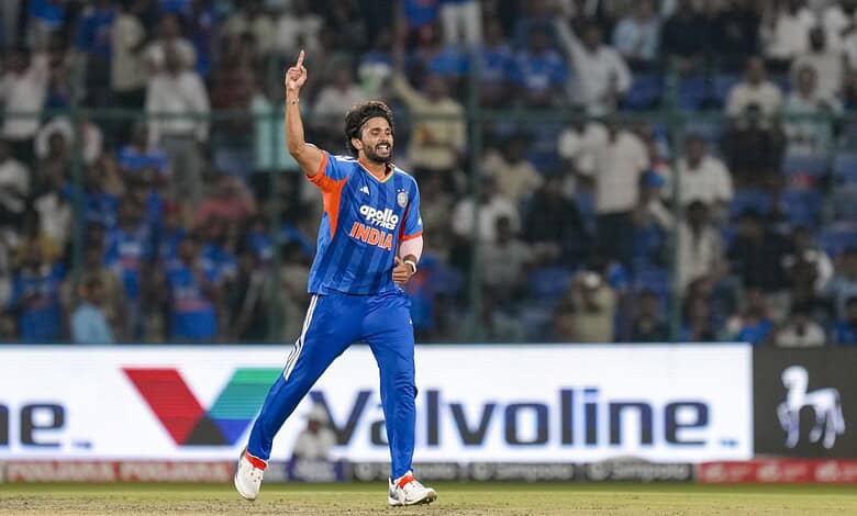Indian cricket player celebrating on the field during a match in blue jersey.