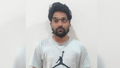 Man with pixelated face wearing grey T-shirt against white background.