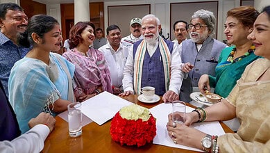 Indian Prime Minister Narendra Modi with women leaders and officials in a meeting room.