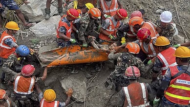 Rescue workers in Nepal recover a body from a collapsed tunnel after flash floods.
