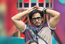 Qazi Touqeer in Bigg Boss 20, wearing glasses and a patterned shirt, with a serious expression.
