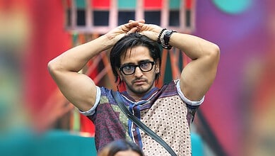 Qazi Touqeer in Bigg Boss 20, wearing glasses and a patterned shirt, with a serious expression.