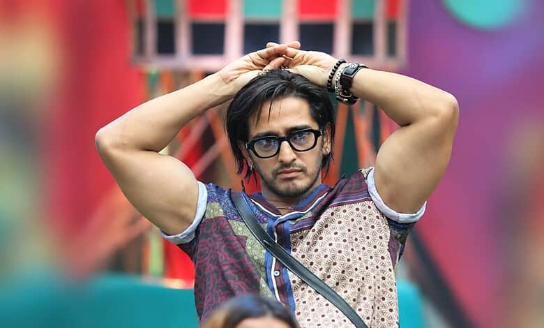 Qazi Touqeer in Bigg Boss 20, wearing glasses and a patterned shirt, with a serious expression.