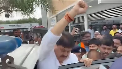 Protesters gather around a man raising his fist during a demonstration.