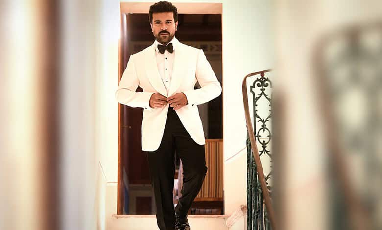 Man in white tuxedo with black bow tie standing at doorway, stylish and confident.