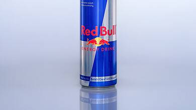 Close-up of a Red Bull energy drink can on a plain background.