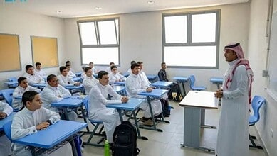 Saudi teacher addressing students in a classroom in Riyadh.