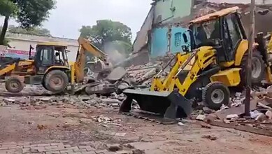 Construction machinery demolishing a building in Saharanpur after court rejection.