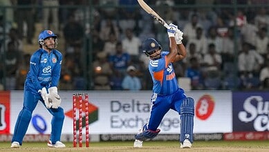 Indian cricket players in action during a match, one batting and one wicketkeeper behind the stumps.