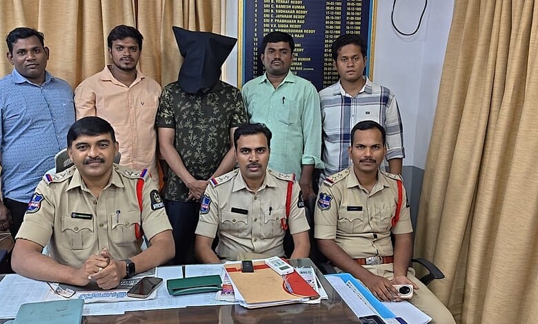 Police officers and a person with a black hood in a room with a board and curtains.