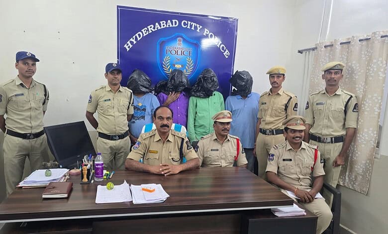 Hyderabad City Police officers with detained individuals in police station office.