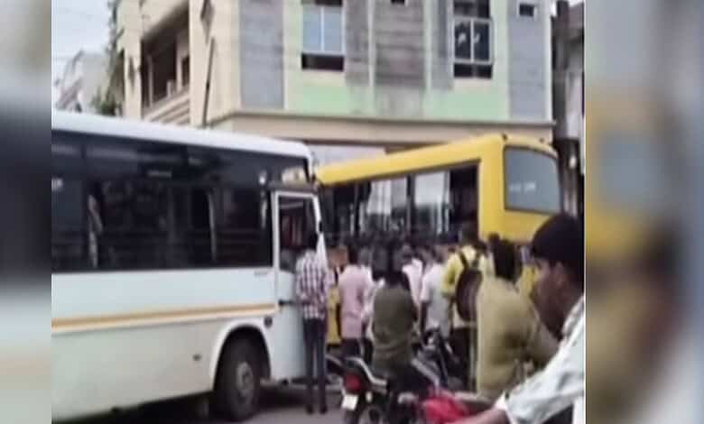 Crowd gathers around a bus after a collision with a school bus in Sircilla, two children injured.