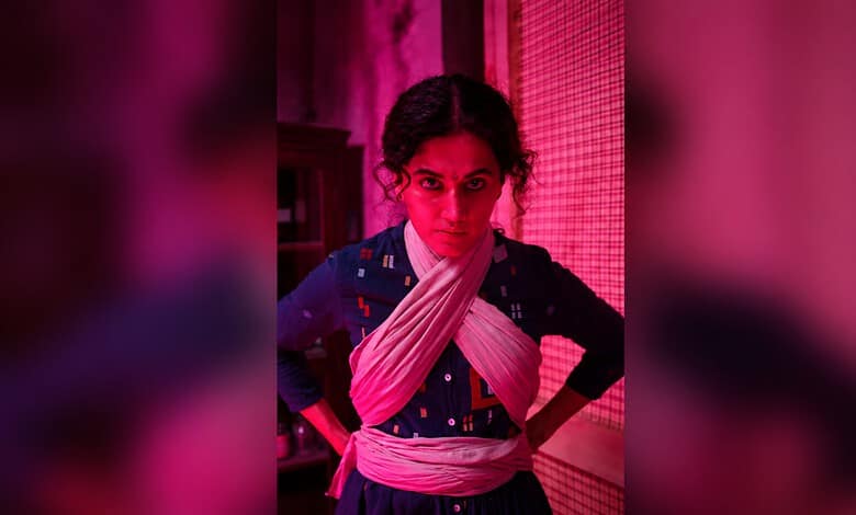 Taapsee Pannu in a traditional outfit with intense expression, pink lighting background.