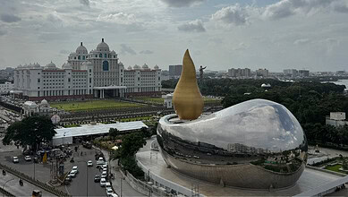 The iconic Pearls of the City sculpture in Hyderabad, India, with a government building in the background.