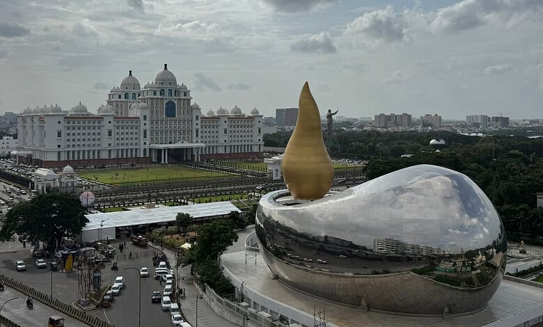 The iconic Pearls of the City sculpture in Hyderabad, India, with a government building in the background.