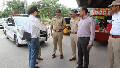 Police officers and officials discussing near police vehicle at Gachibowli, Hyderabad.