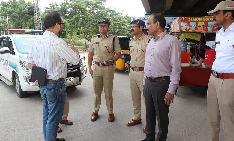 Police officers and officials discussing near police vehicle at Gachibowli, Hyderabad.