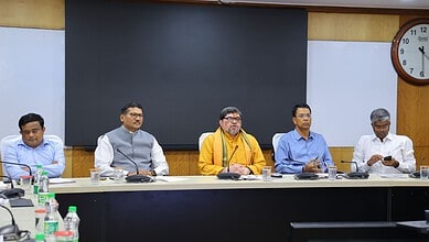 Group of five men seated at a conference table during a formal meeting.