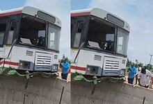 Bus accident with front damage and people inspecting the scene.