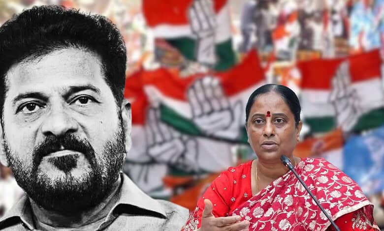 Konda Surekha speaking at a political event with Indian flags in the background.