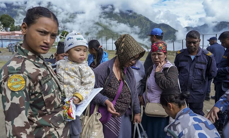 Nepalese stranded in China return home, women and children among crowd at border.