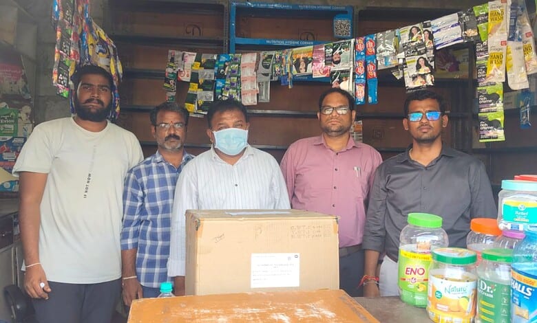 Group of five men standing in a shop with shelves of products behind them.