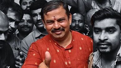 Raja Singh smiling in a red kurta amidst a crowd, with some faces in black and white.
