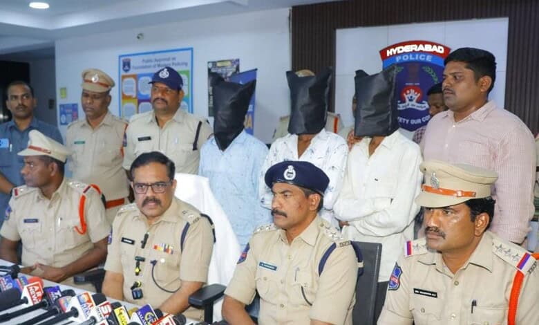 Police officers and suspects with covered faces during a press conference in Hyderabad.