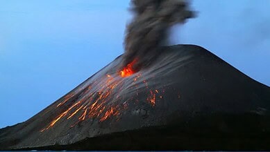 An erupting Anak Krakatau volcano with ash and lava spewing into the sky.