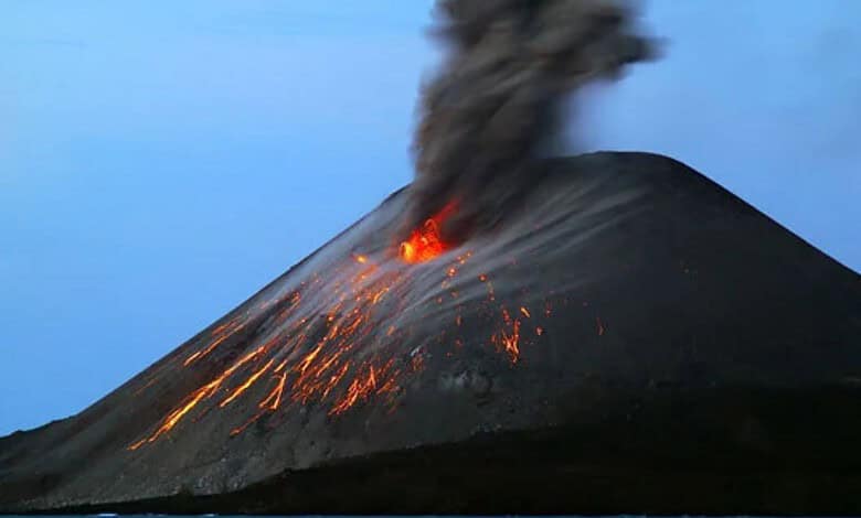 An erupting Anak Krakatau volcano with ash and lava spewing into the sky.